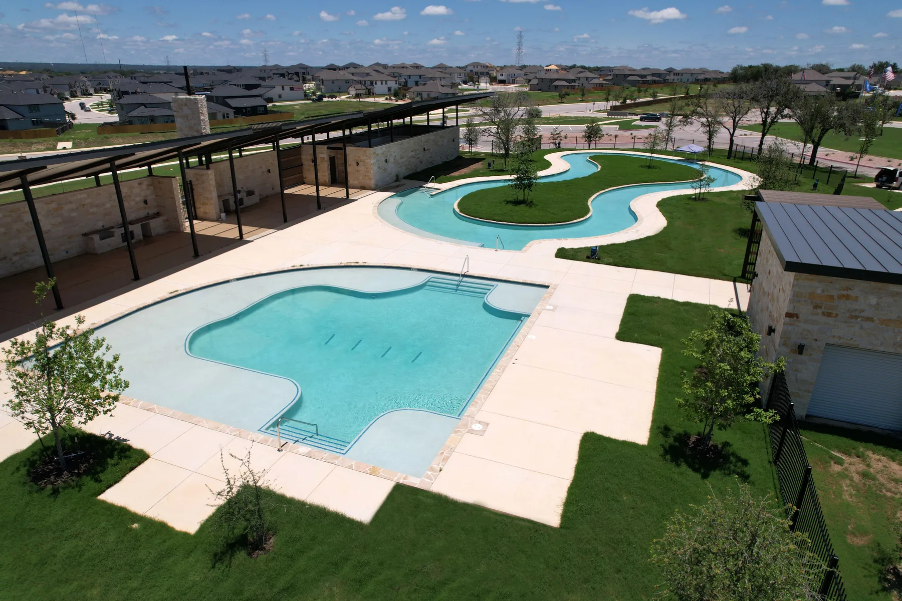 Hickory Ridge amenity center featuring a resort-style pool, open-air pavilion, and stone clubhouse in Elmendorf, TX
